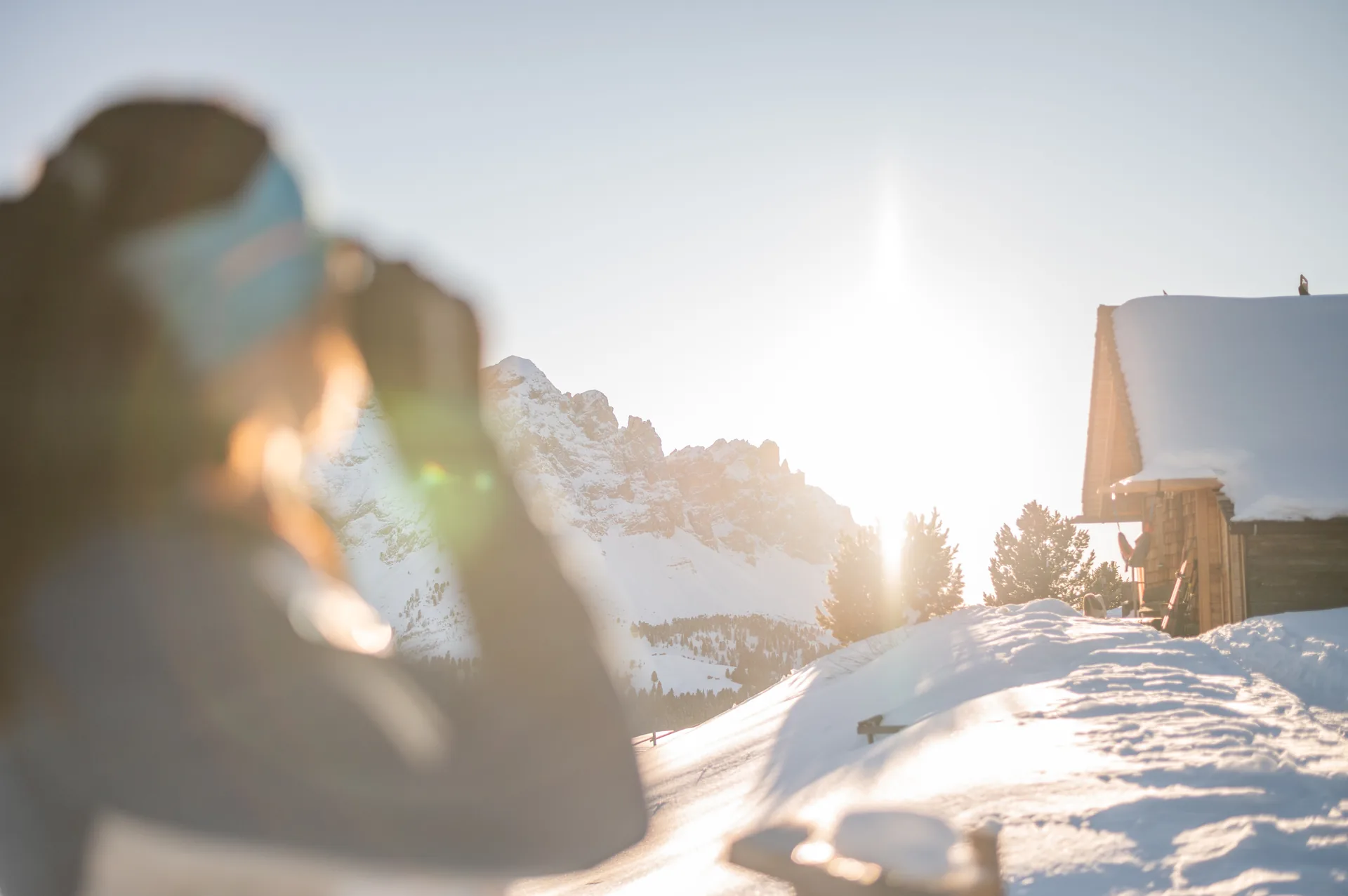 Wintersonne über einer verschneiten Berghütte